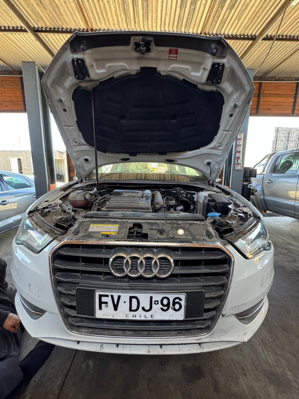 Audi A3 con el capó abierto, bajo techo