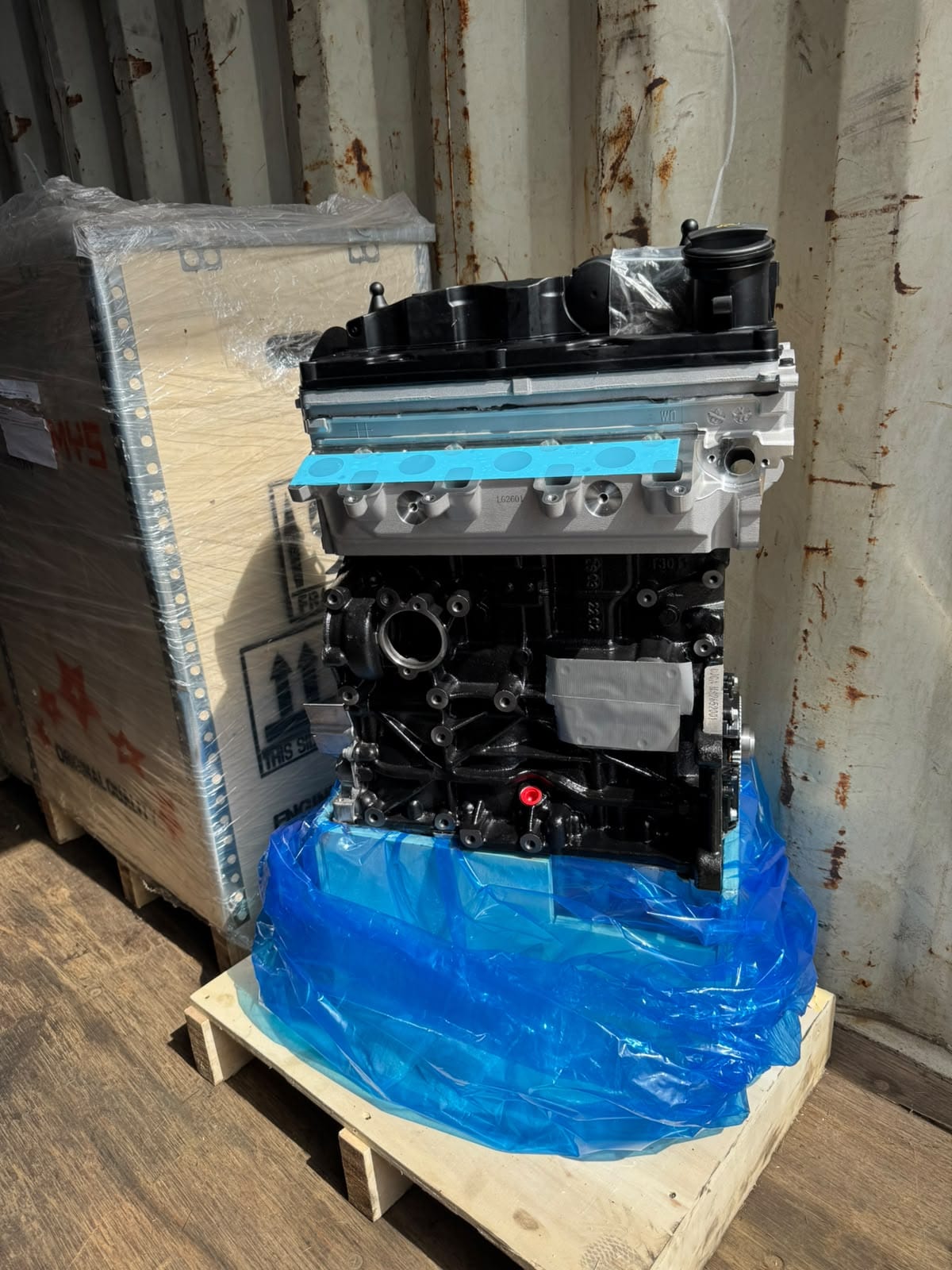 Motor 2.0 BiTDI nuevo para Volkswagen Amarok, sobre su pallet y envuelto en plástico azul, junto a su cajón